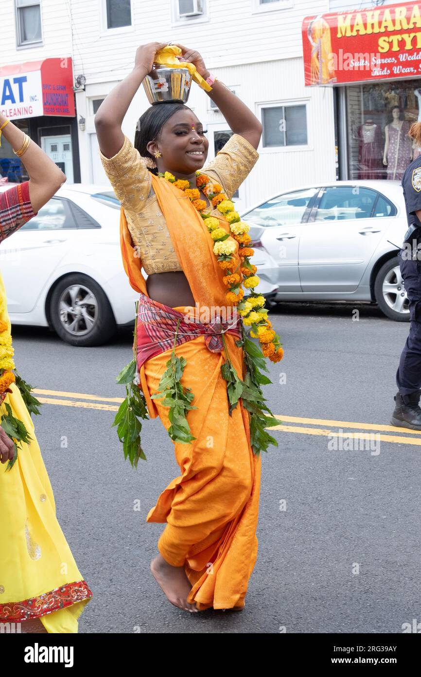 An attractive Hindu woman marches to the Thimithi fire walking ceremony while holding offerings on her head. In Richmond Hills Queens, New York. Stock Photo