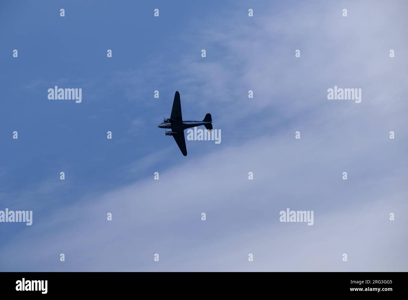 Helsinki / Finland - JULY 28, 2023. An old propeller passenger airplane flying against a cloudy morning sky. Stock Photo