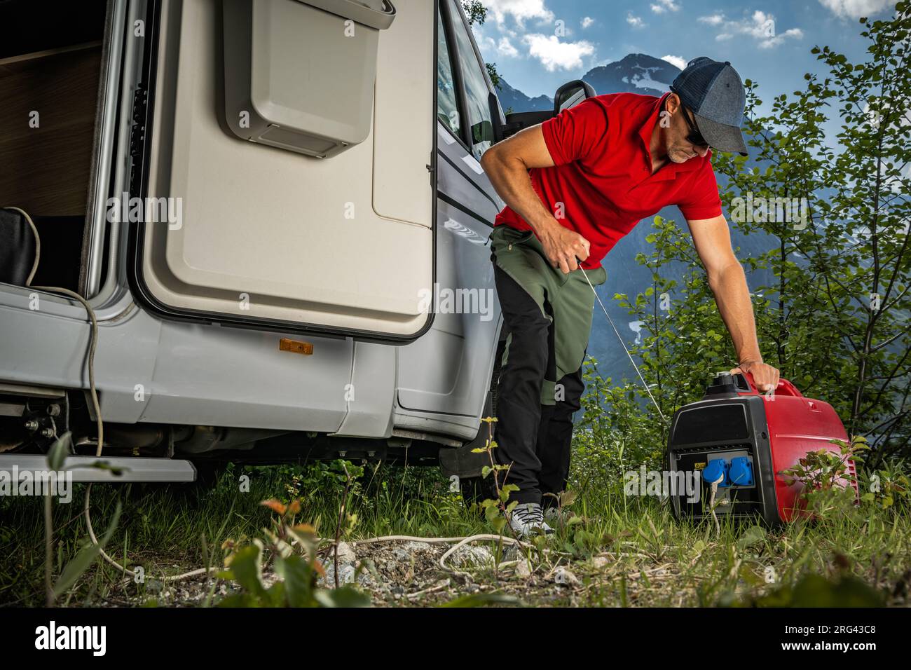 Tourist Firing Portable Inverter Generator While Dry RV Camping in Remote Wilderness Location Stock Photo