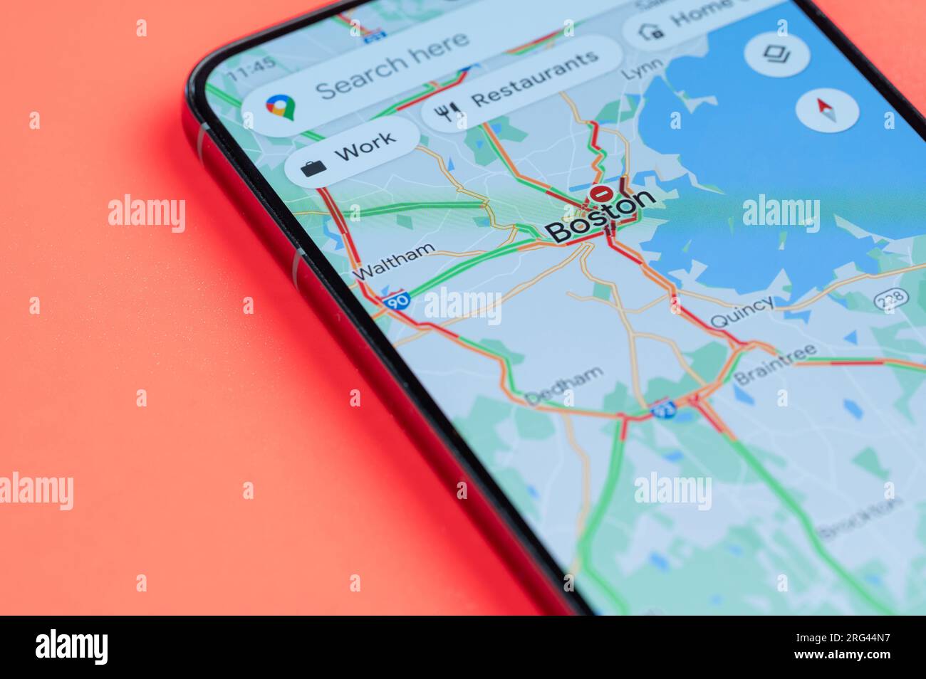 New York, USA - July 21, 2023: Car traffic on Boston google maps on smartphone screen close up view with red background Stock Photo
