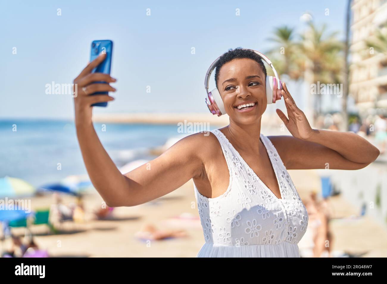 African american woman smiling confident having video call at seaside ...