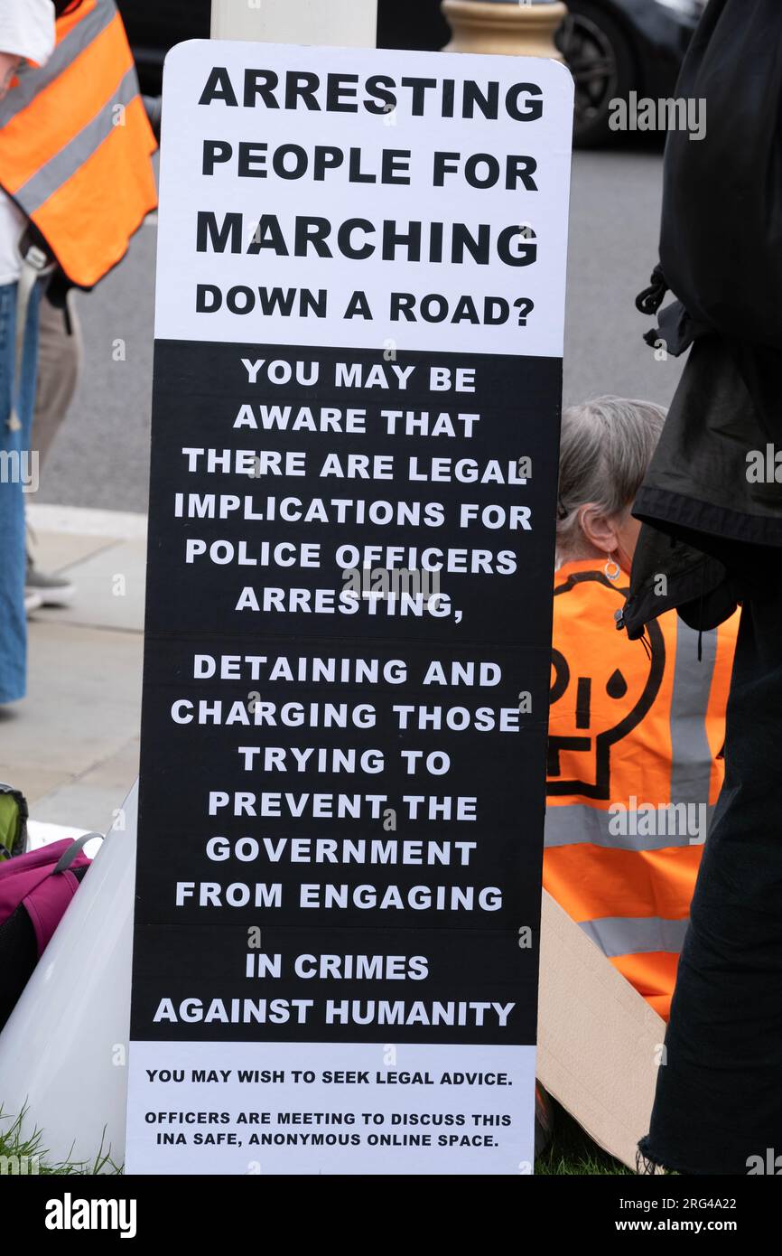 Just Stop Oil activists with sign on Parliament Square, campaigning for