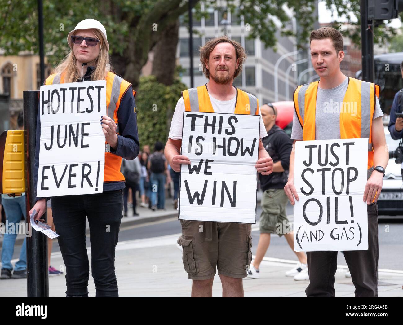 Just Stop Oil activists holding protest signs in central London, campaigning for the government to stop all future fossil fuel licensing & production. Stock Photo