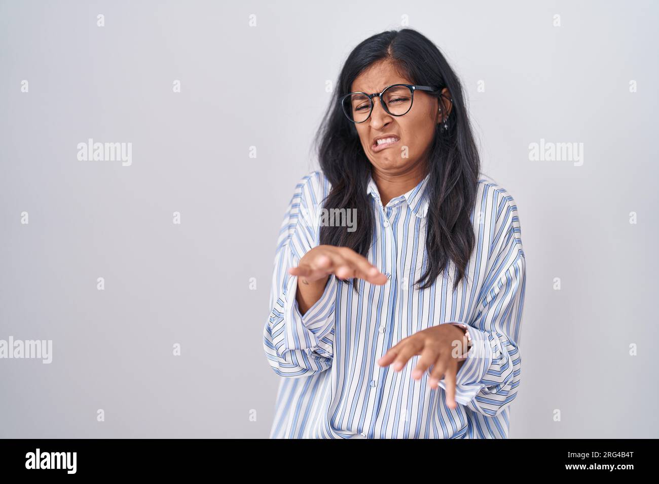 Young hispanic woman wearing glasses disgusted expression, displeased ...