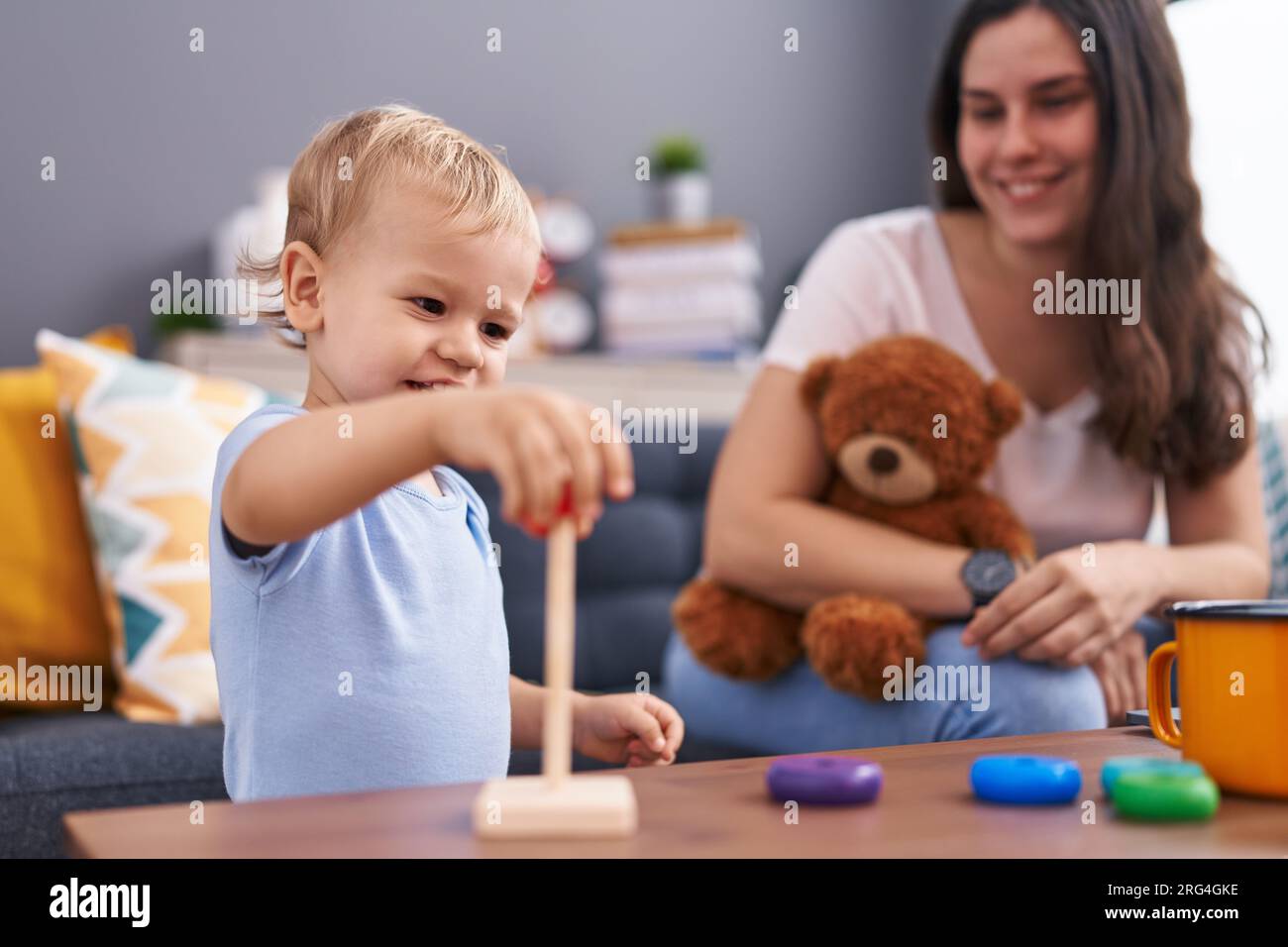 Mother and son holding teddy bear playing at home Stock Photo - Alamy