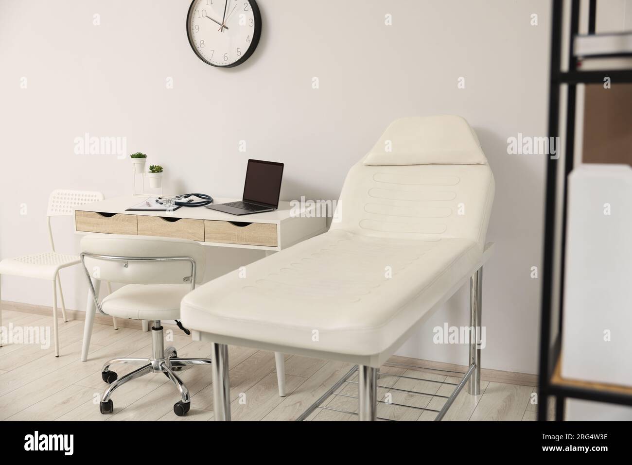 Modern medical office with doctor's workplace and examination table in ...