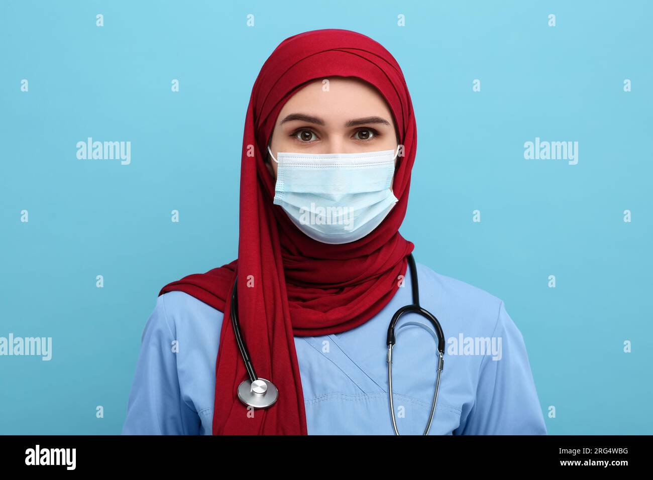 Muslim woman wearing hijab, medical uniform and protective mask on