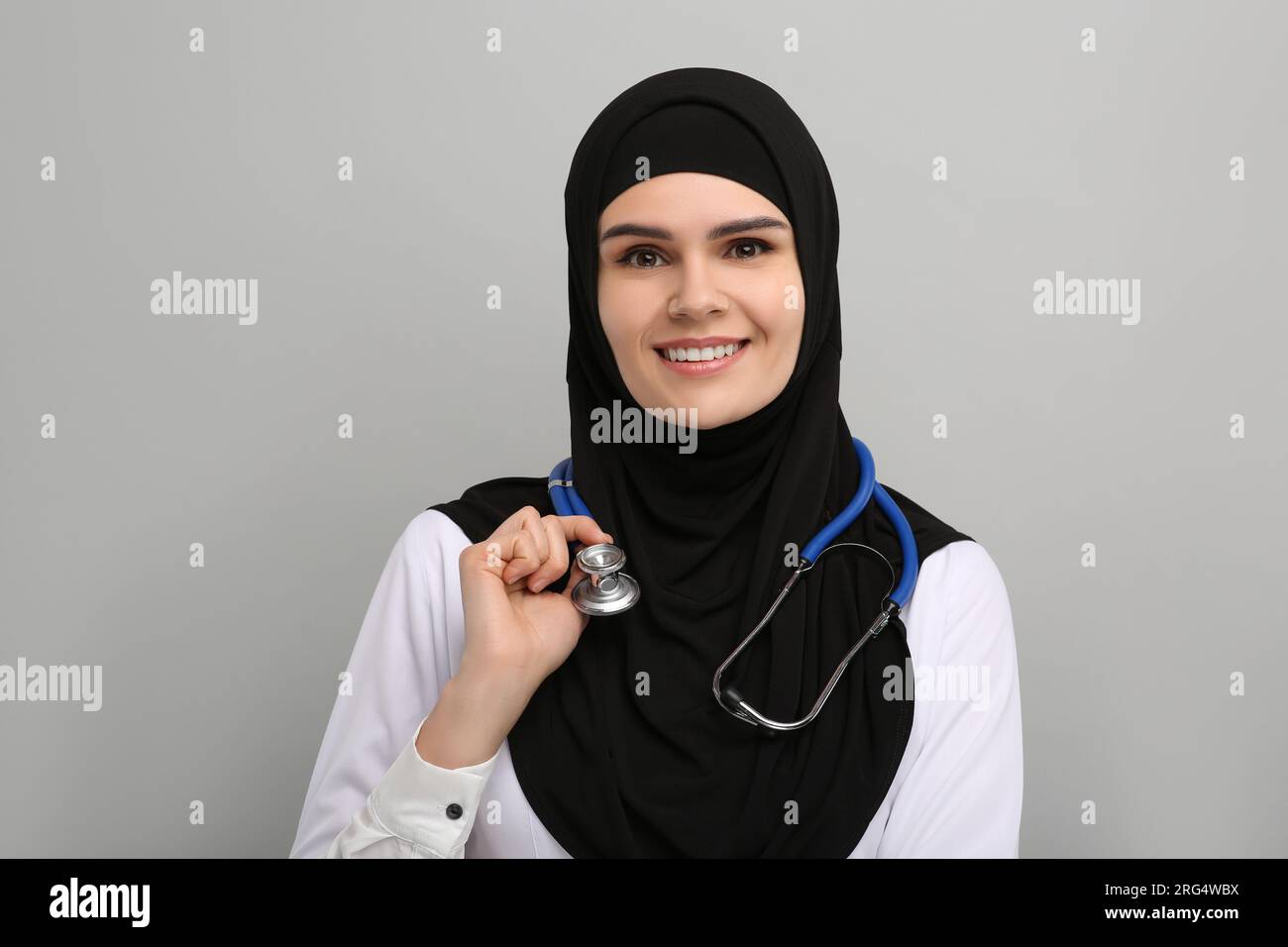 Muslim woman wearing hijab, medical uniform with stethoscope on light