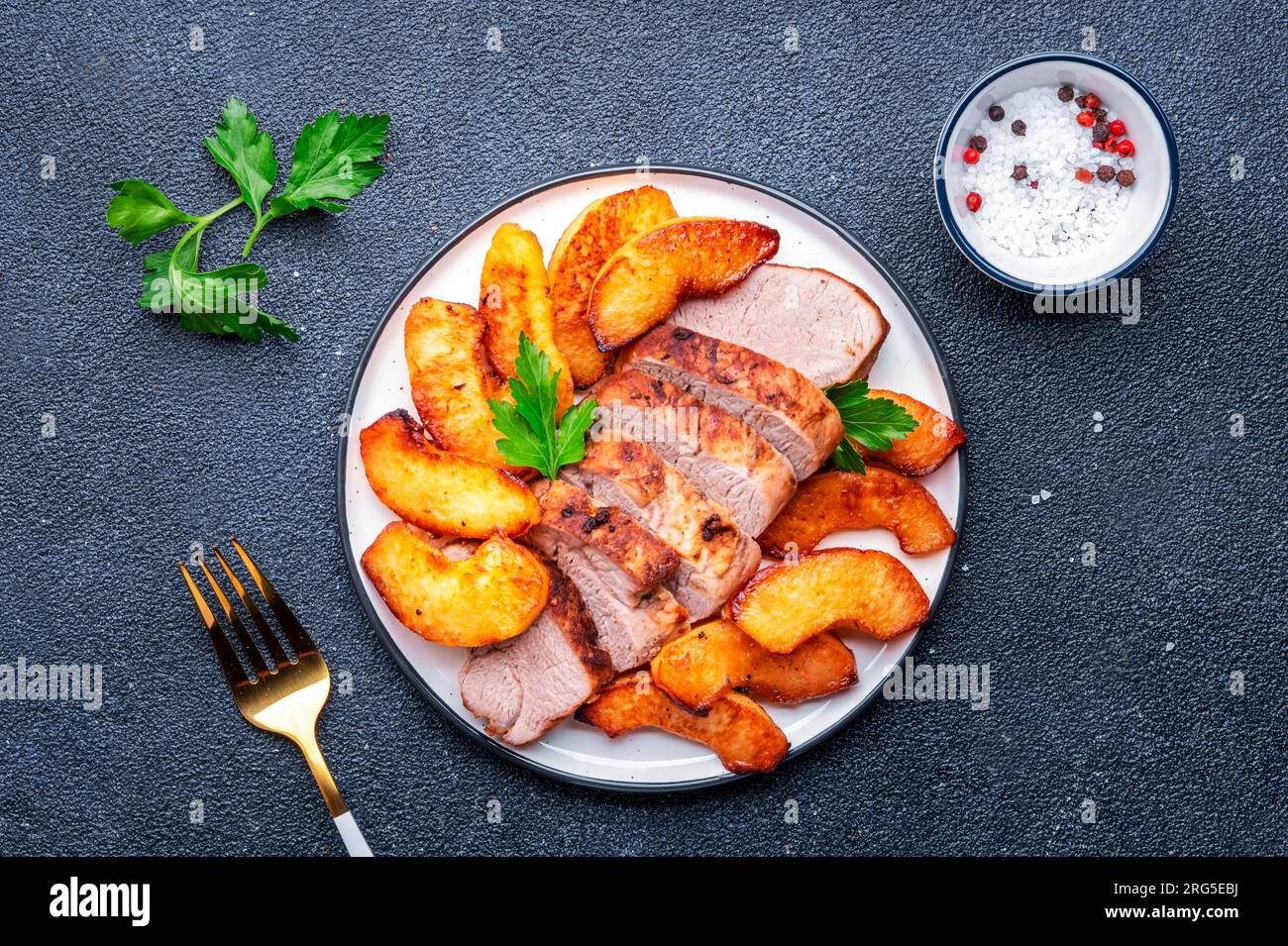 Baked pork tenderloin with sweet quince or apple slices served on white