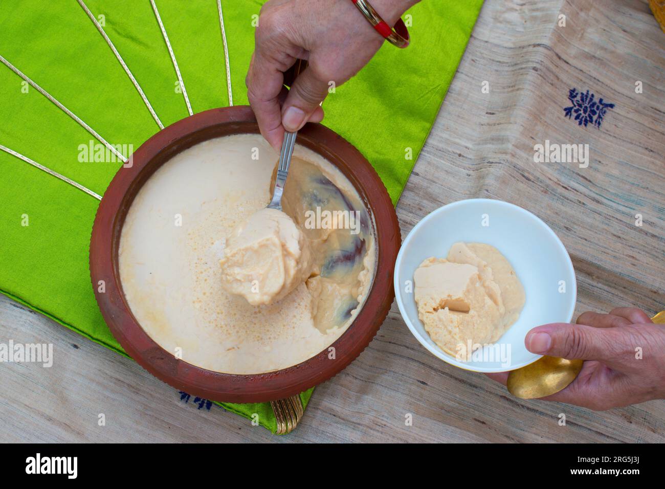 Homemade Mishti Doi or sweet dahi or curd made with milk and sugar or jaggery in earthen pot. It is popular Indian dessert of West Bengal, Assam Stock Photo