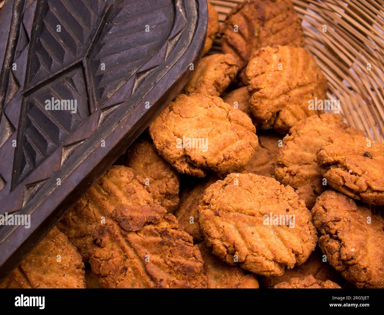 Thekua , an Indian sweet dish or a snacks in bamboo or wooden basket or tokri with mold in wooden table. popular in bihar jharkhand. Prashad in chhath Stock Photo