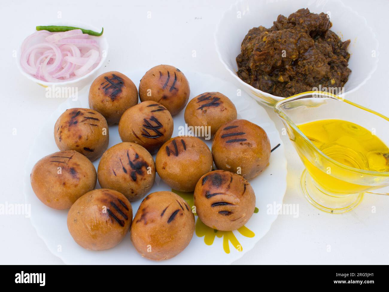 Litti with chicken, ghee and onion ring. It is popular in Bihar, Uttar Pradesh and Jharkhand. White background Stock Photo