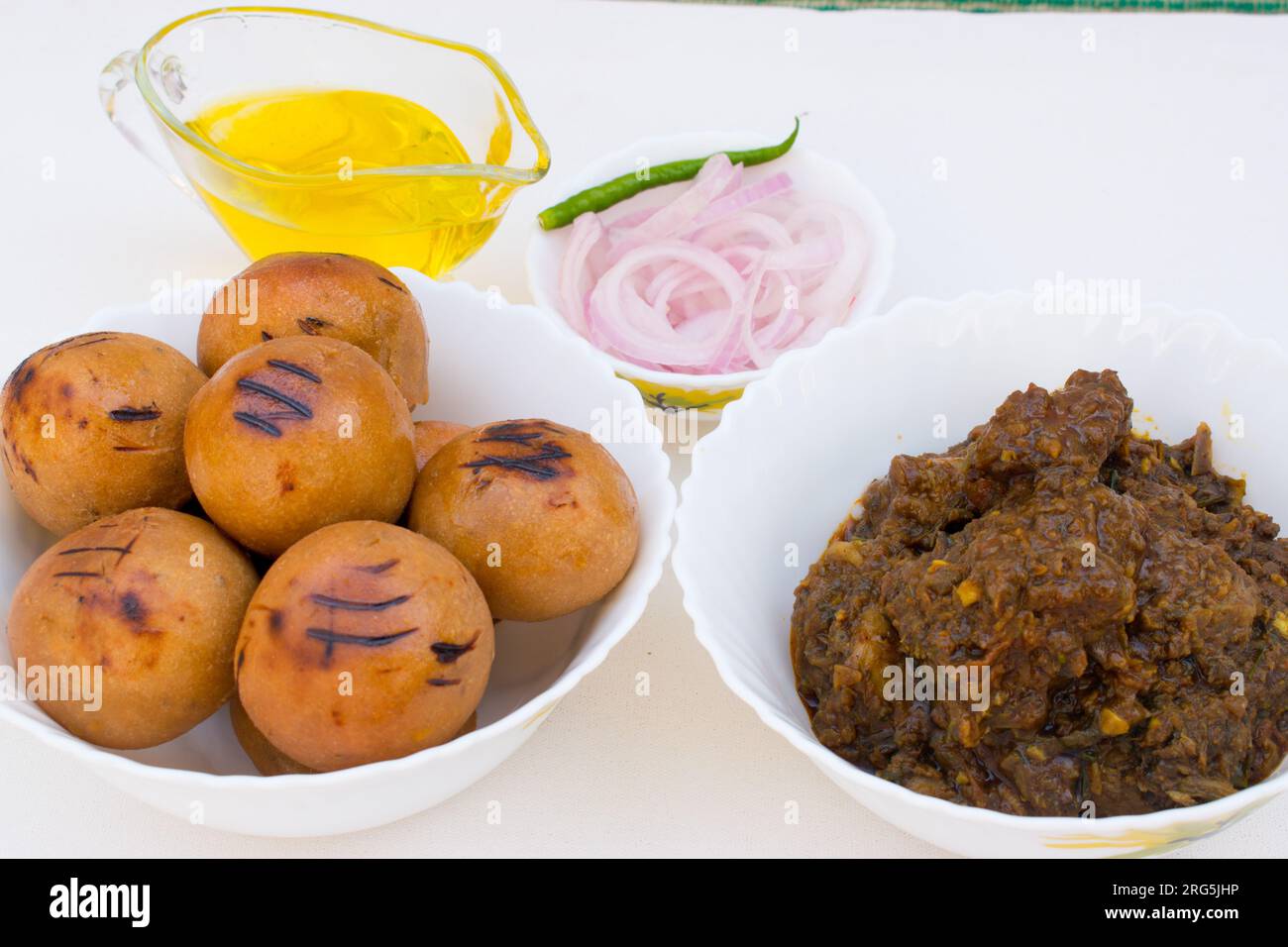 Litti with chicken, ghee and onion ring. It is popular in Bihar, Uttar Pradesh and Jharkhand. White background Stock Photo