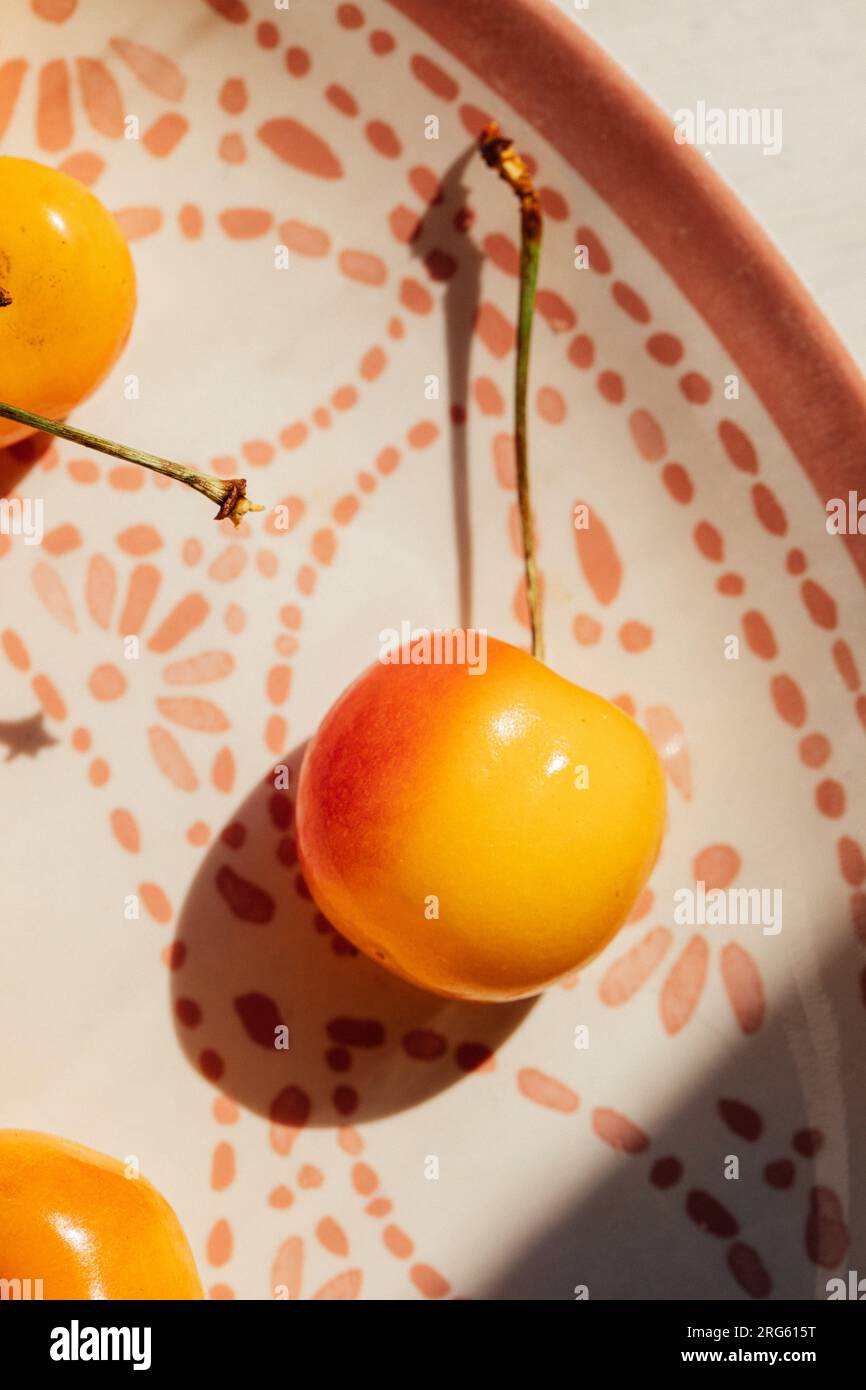 close up of Rainier cherry on moroccan pink and white patterned platter Stock Photo