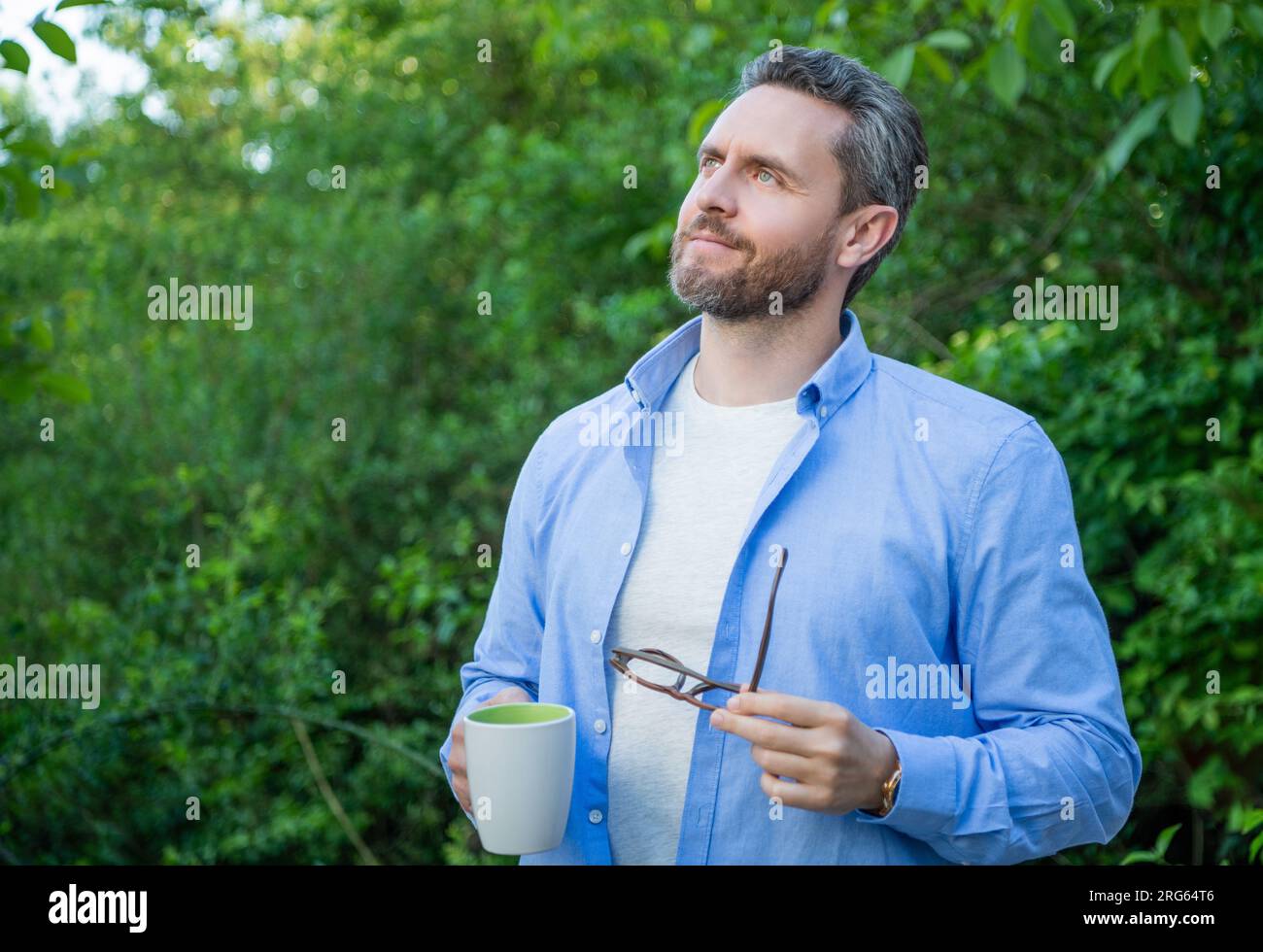 lifestyle photo of dreamy man with coffee in the morning outdoor Stock