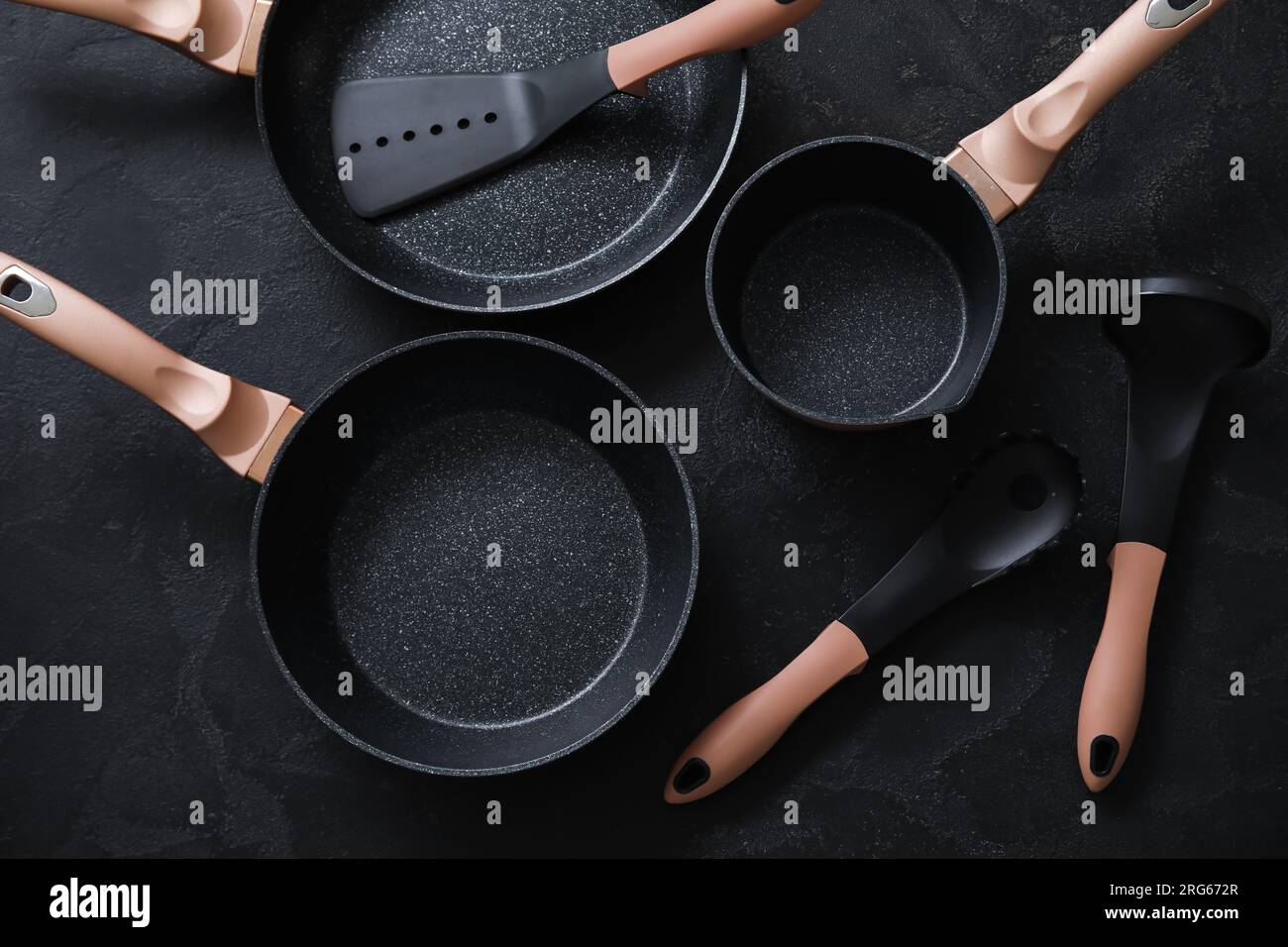 Set of cooking pots and kitchen utensils on dark background Stock Photo