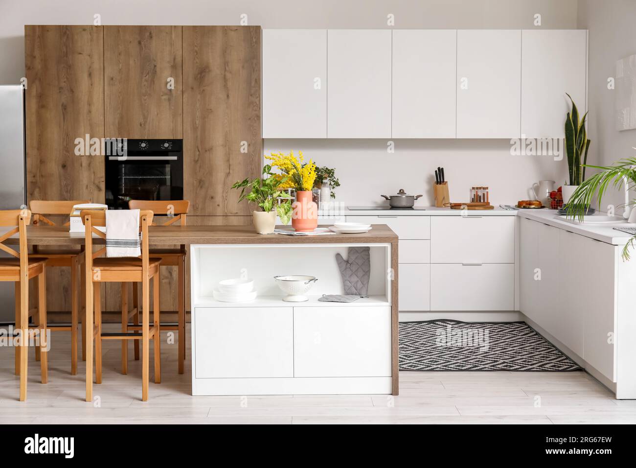 Interior of light kitchen with white counters, island and integrated ...