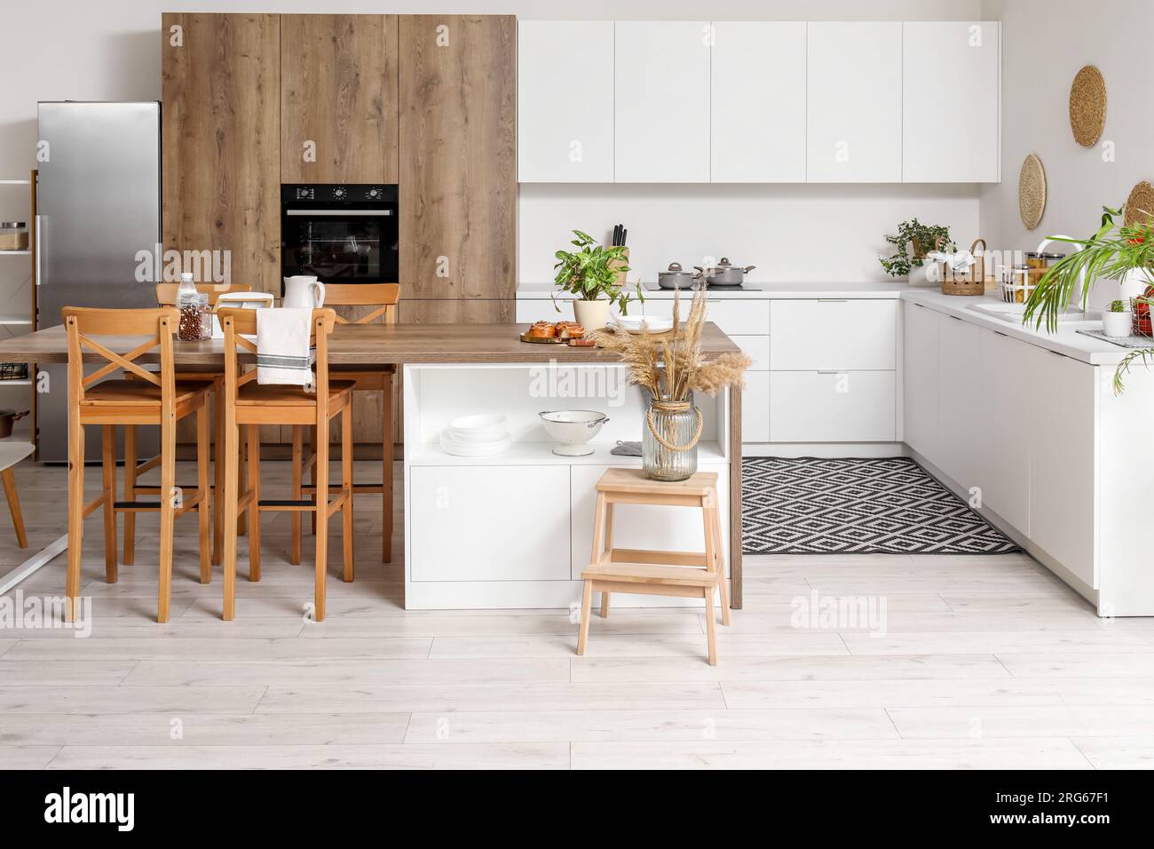 Interior of light kitchen with white counters, island and integrated ...