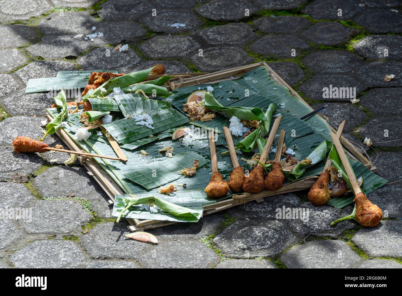 An offering of sate lilit, a traditional Balinese dish, outside a emple, Penglipuran Village, Bangli Regency, Bali, Indonesia Stock Photo