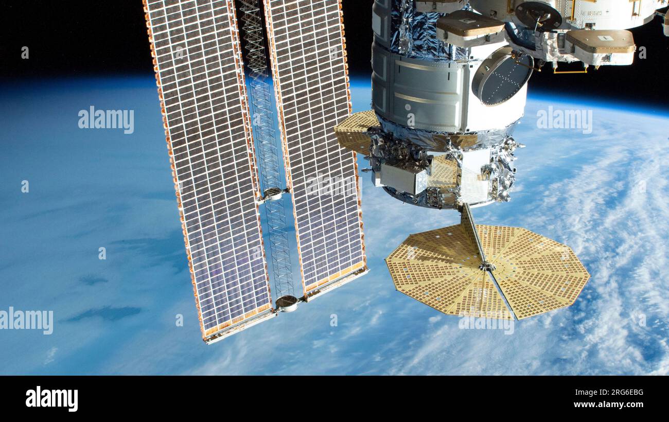 The Cygnus cargo spacecraft and ISS solar arrays pictured above the South Atlantic Ocean. Stock Photo