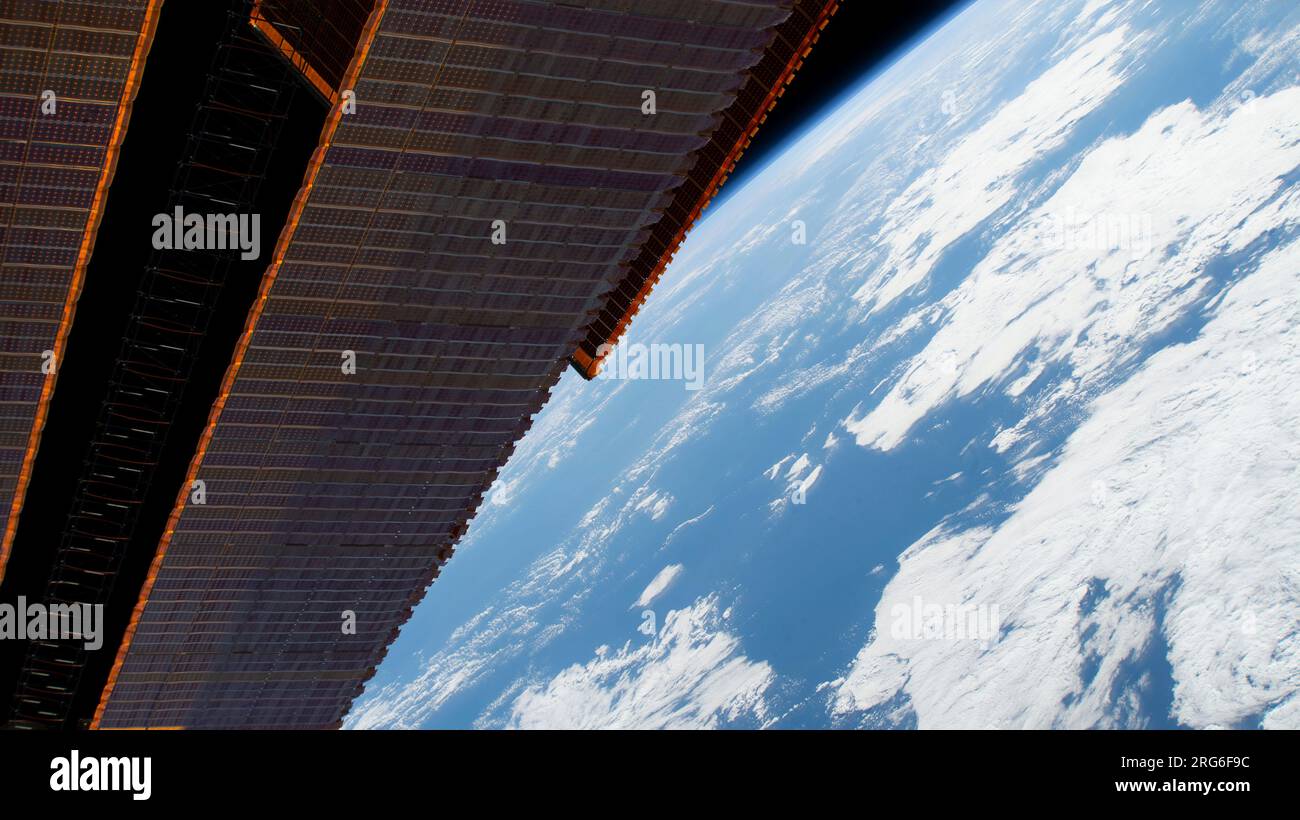 A portion of the International Space Station's main solar arrays as it flies above the Pacific Ocean. Stock Photo