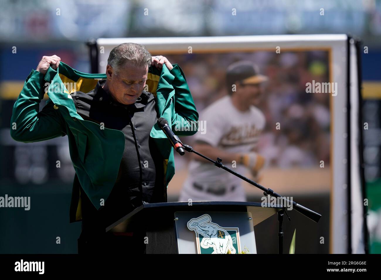 Jason Giambi adjusts his Oakland Athletics' Hall of Fame jacket