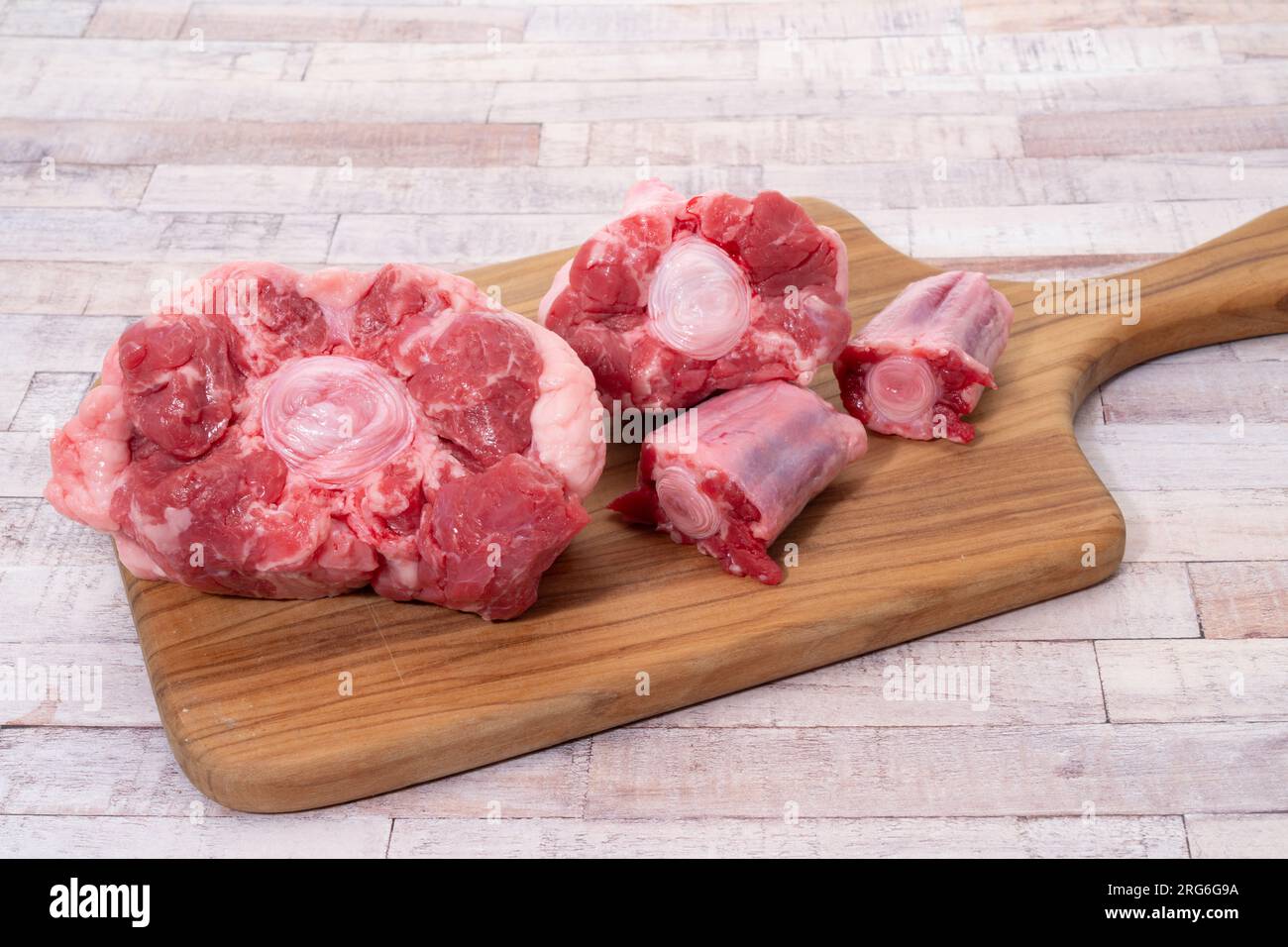 Fresh raw ox tail on a wooden cutting board Stock Photo