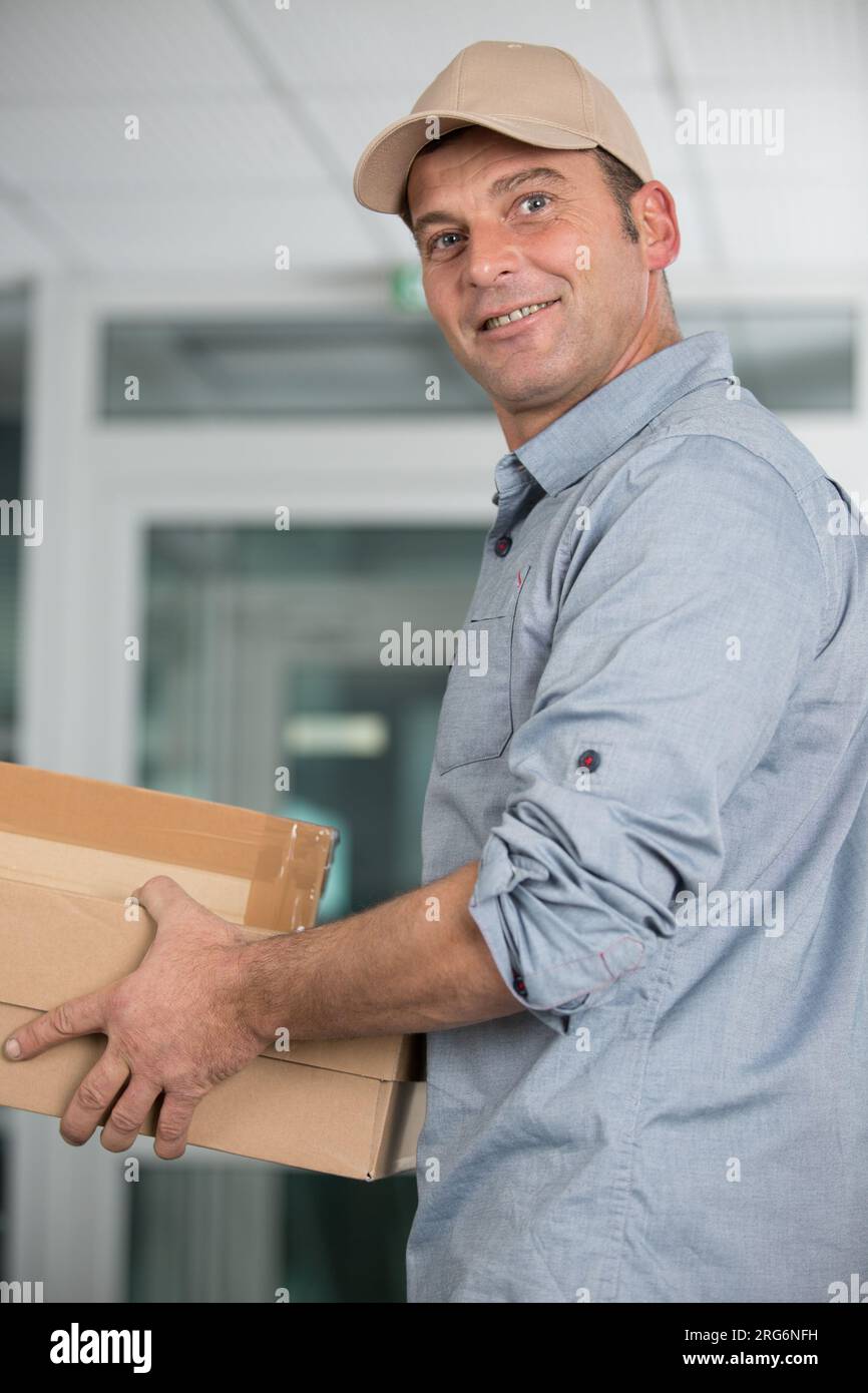 delivery man delivering parcel box to recipient Stock Photo Alamy
