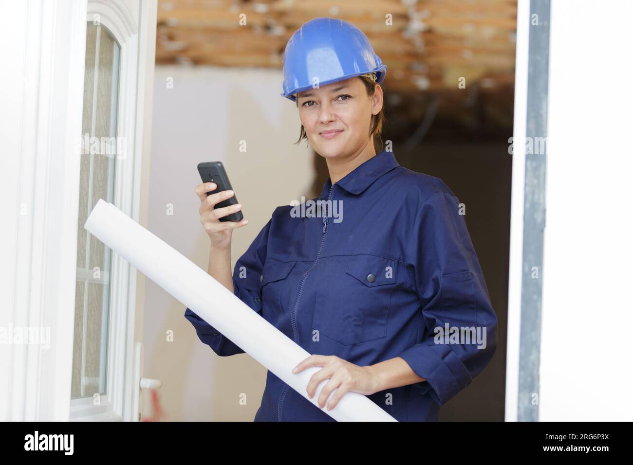 architect in helmet with paper documents holding her phone Stock Photo ...