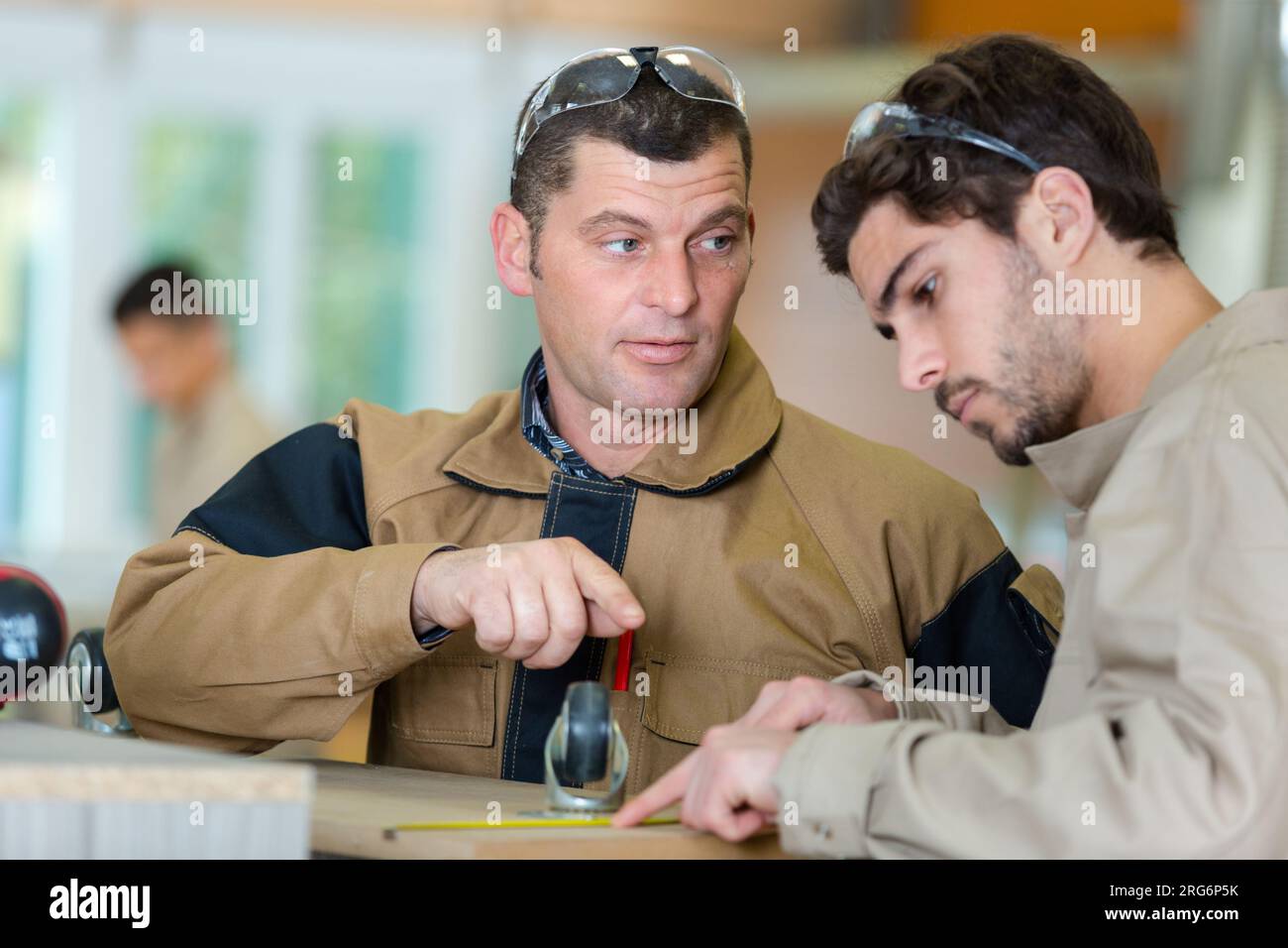 two carpenters discussing something in workshop Stock Photo