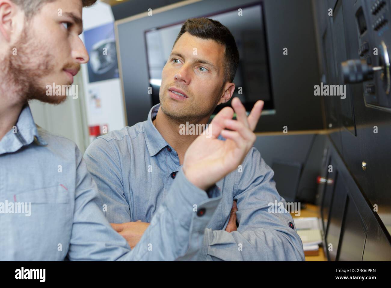 factory manager and engineering apprentice talking Stock Photo