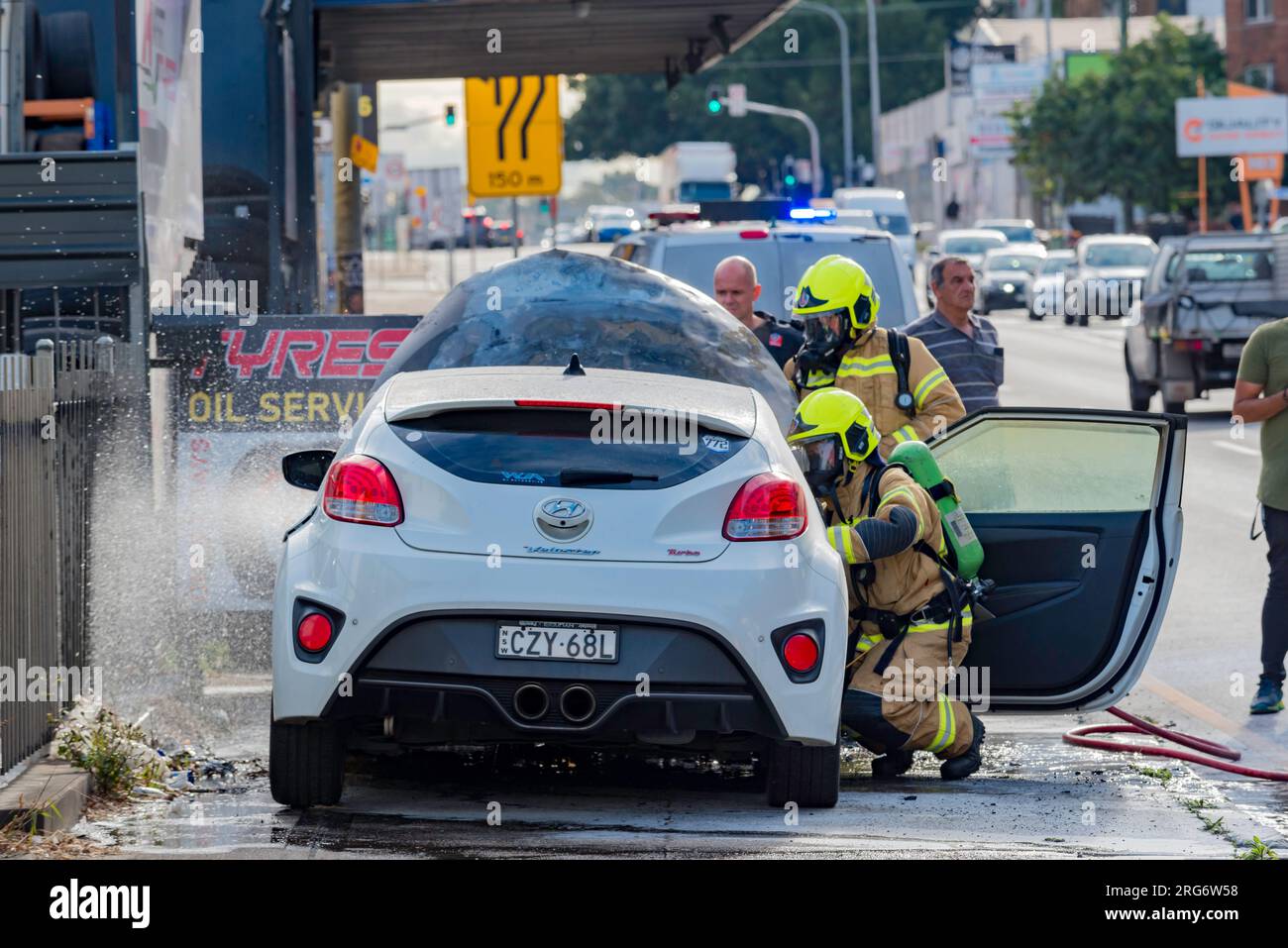 August 07, 2023: Members of Fire and Rescue NSW (FRNSW) attending a roadside car fire on Parramatta Road in western Sydney, New South Wales, Australia Stock Photo