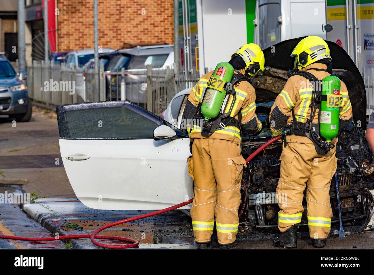 August 07, 2023: Members of Fire and Rescue NSW (FRNSW) attending a roadside car fire on Parramatta Road in western Sydney, New South Wales, Australia Stock Photo