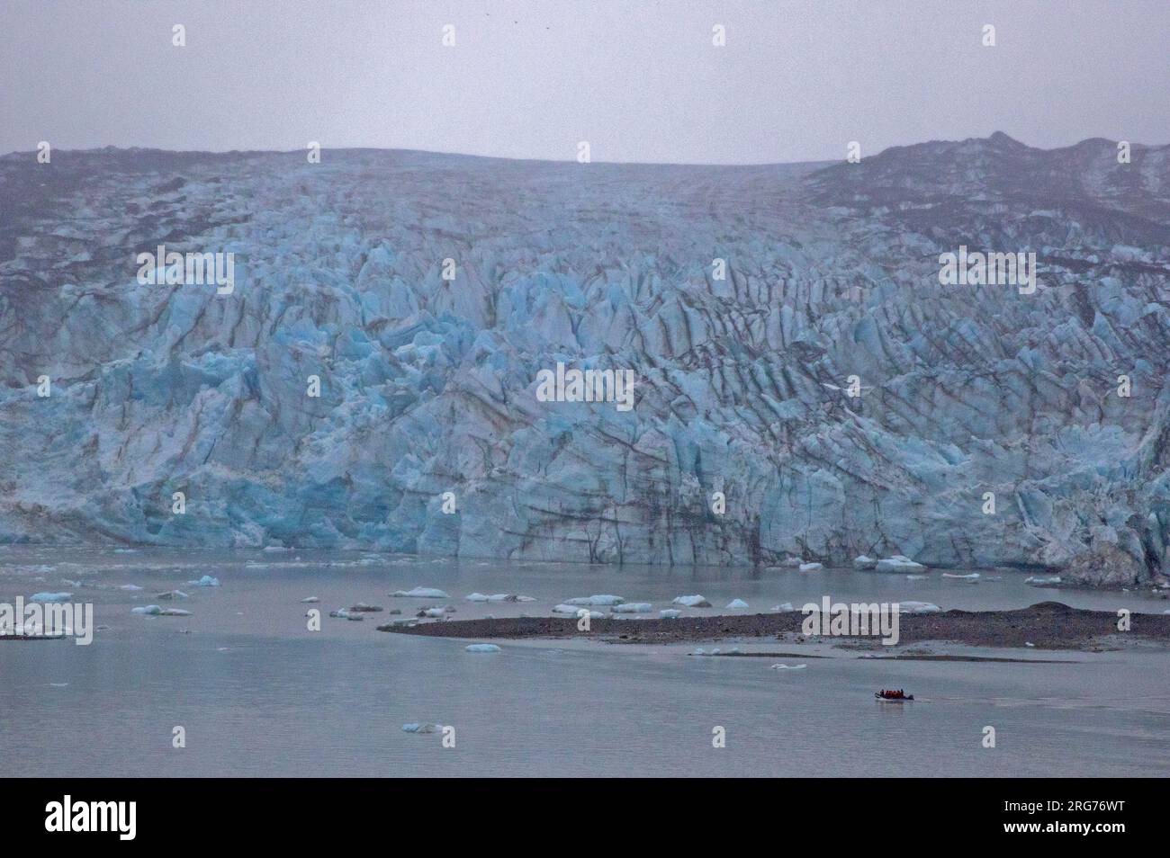 Zodiac motoring beneath Lamplugh Glacier, Glacier Bay National Park Stock Photo
