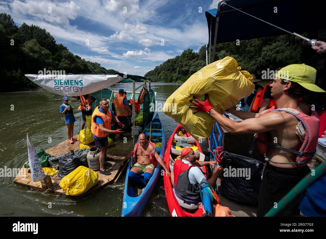 Volunteers offload their boat after it overloaded with collection bags  while attending the Plastic Cup event near Tiszaroff, Hungary, on Aug. 2,  2023. Since its start in 2013, participants in the annual