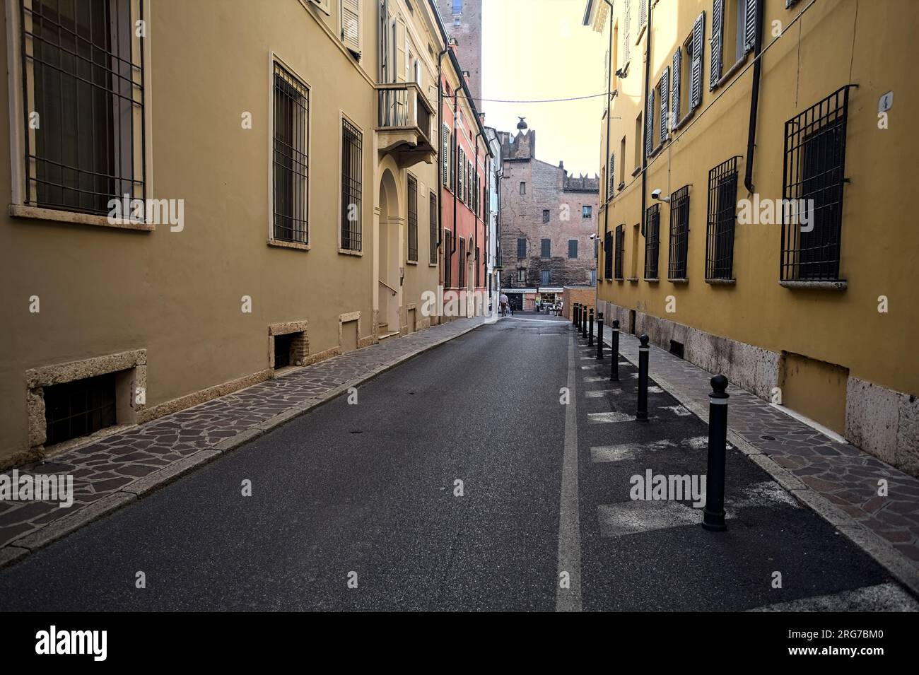 Descending  street between historical buildings in an italian town at sunset Stock Photo