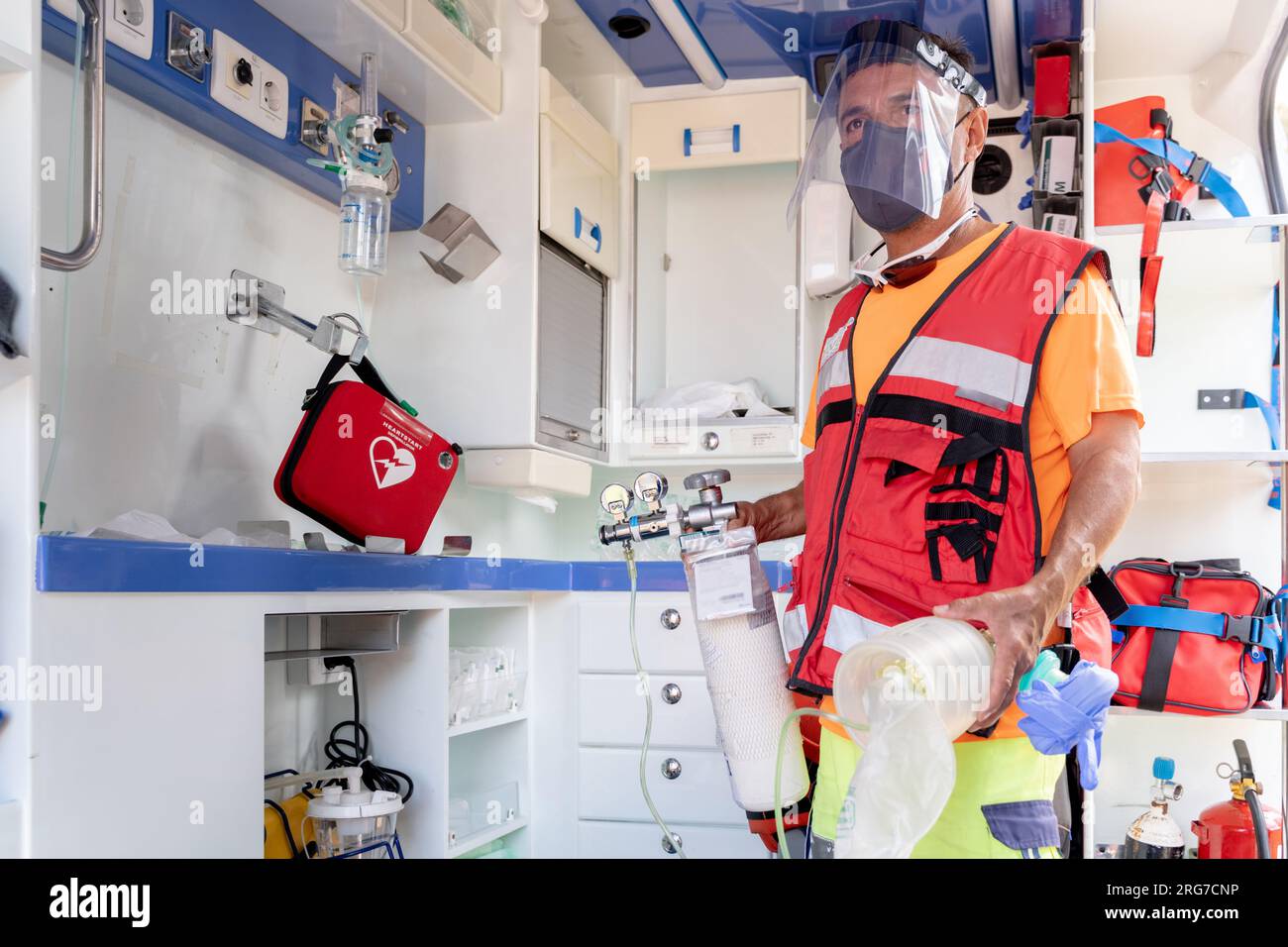 Lifeguard taking an oxygen tank from inside an ambulance Stock Photo ...