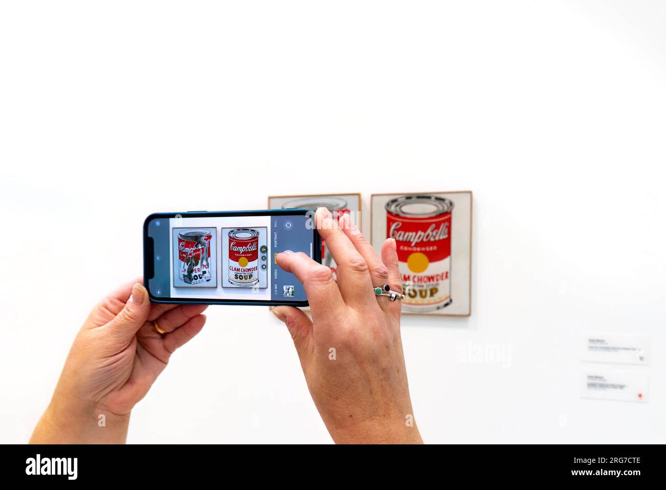 woman in the Broad art gallery Los angeles photographs campbell soup tins painting by Andy warhol on Apple iphone cell mobile Stock Photo