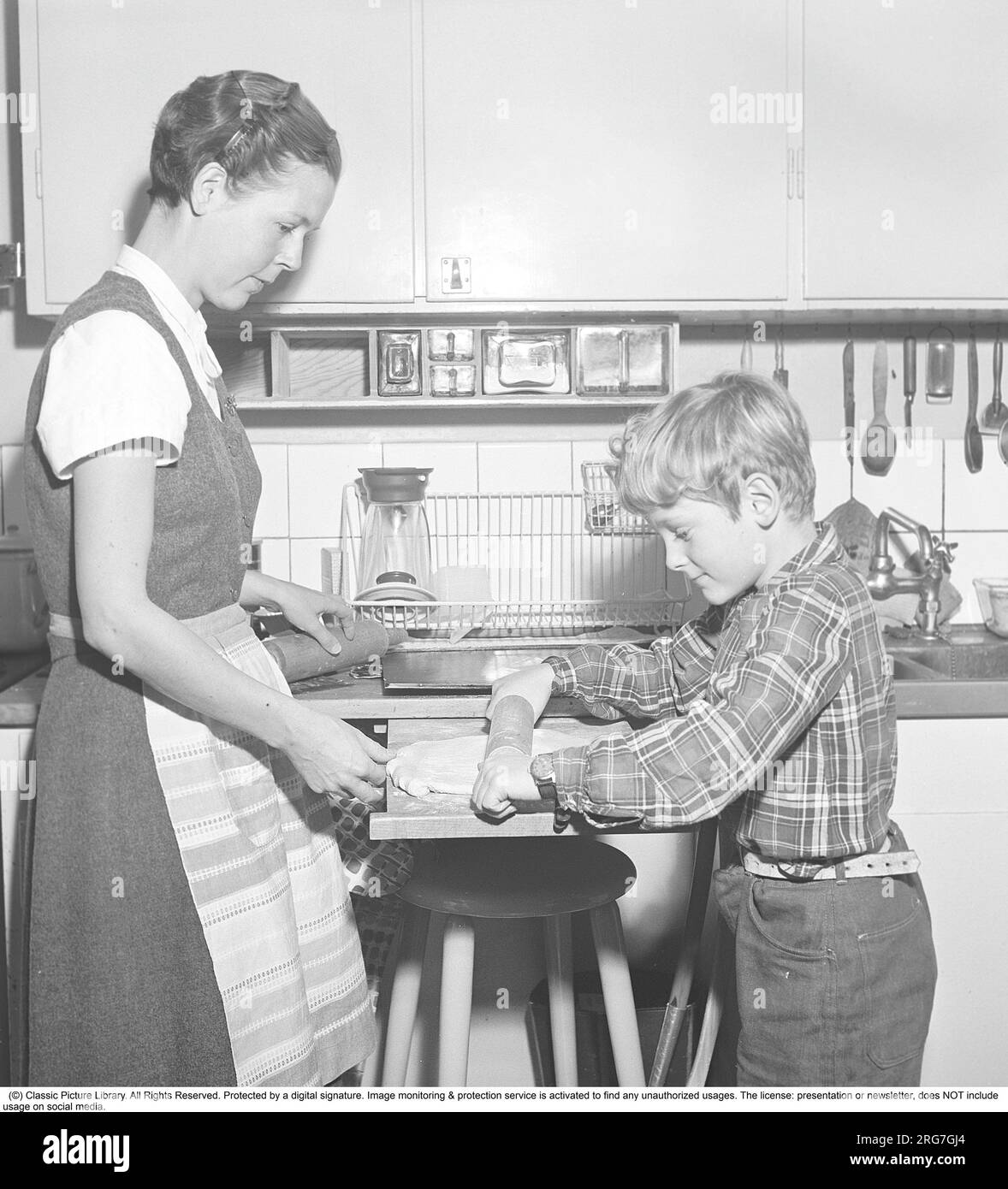 https://c8.alamy.com/comp/2RG7GJ4/baking-in-the-1950s-a-mother-with-her-son-in-the-kitchen-he-helps-her-with-the-baking-rolling-the-dough-on-an-extendable-bench-board-sweden-1958-kristoffersson-ref-by18-11-2RG7GJ4.jpg