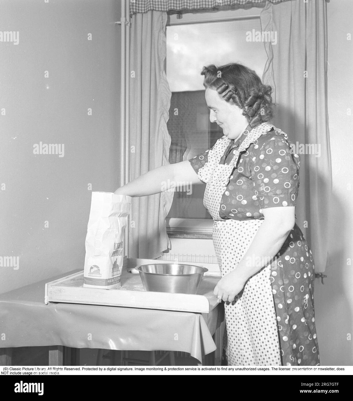 in-the-kitchen-in-the-1950s-an-elderly-lady-looking-very-genuinly