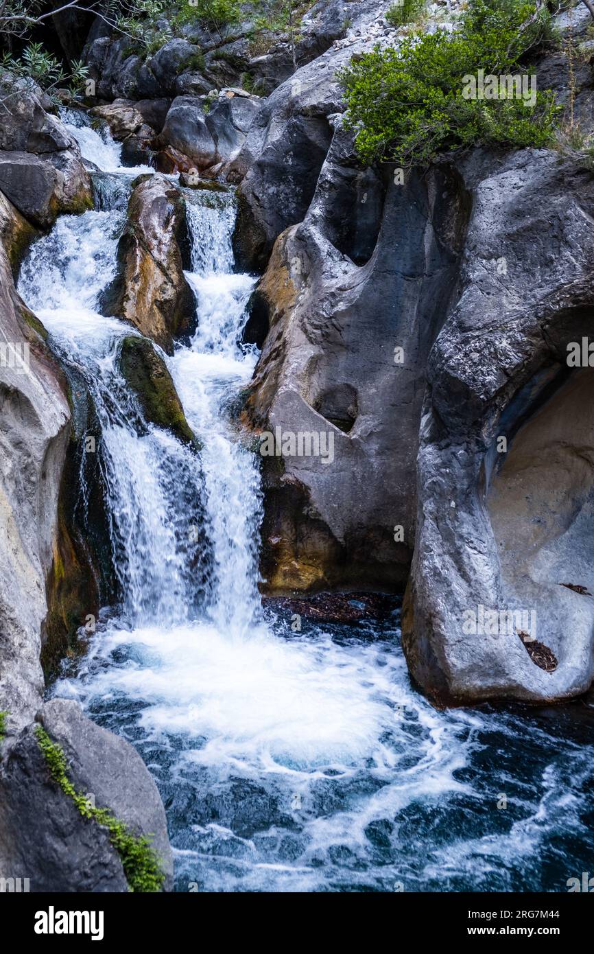 A beautiful mountain gorge with a river and a waterfall Stock Photo
