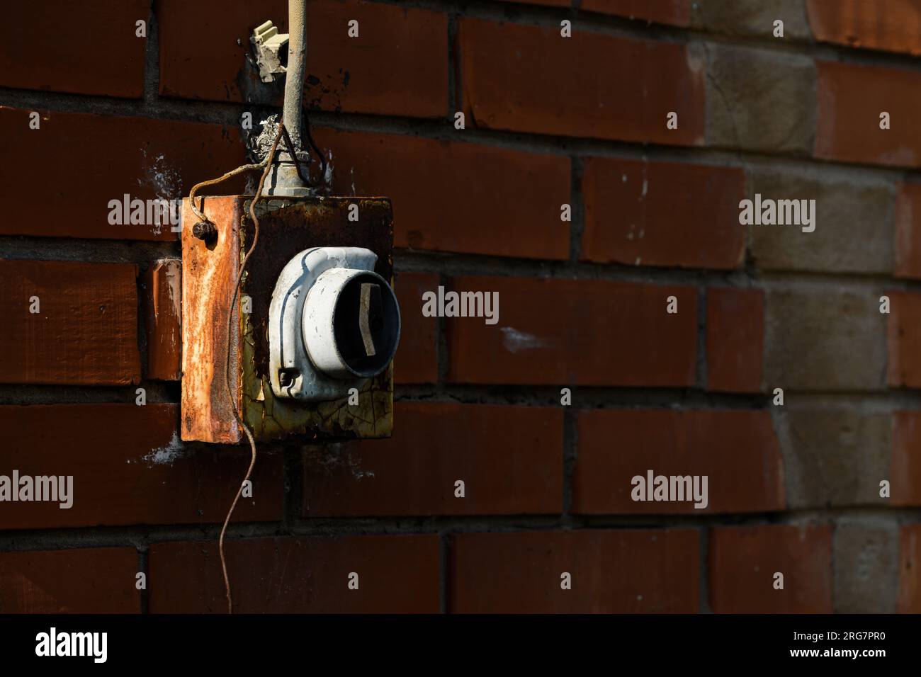Old worn electricity switch on exterior brick wall, selective focus Stock Photo