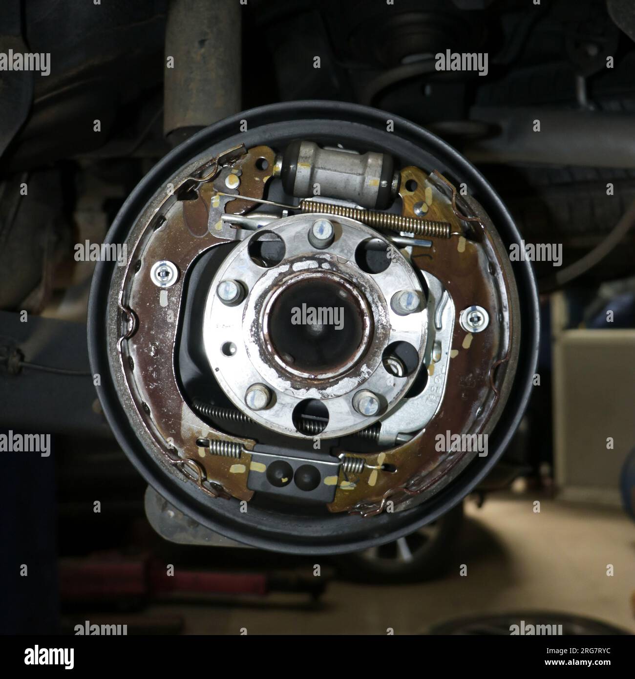 parts of a hydraulic parking drum brake and mechanism in detail under repair and cleaning in a vehicle garage in closeup Stock Photo