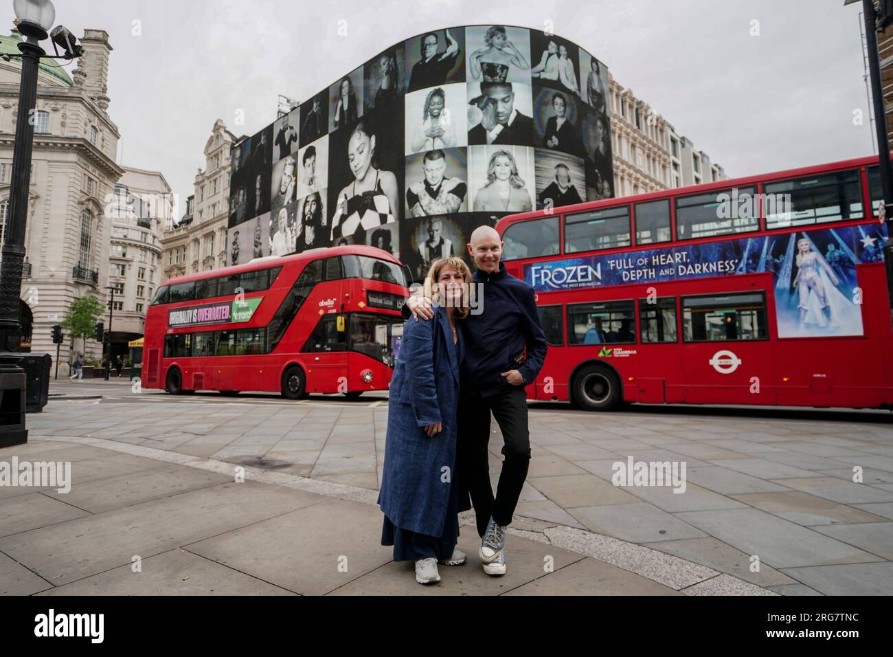 Photographic artist Ray Burmiston with Lara Journo, Director of Take a Moment at the launch of his new exhibition 'Art of London presents Take A Moment 2023' at the Piccadilly Lights, central London. The displays across the West End will feature hundreds of famous faces with their eyes closed for mental health awareness. Picture date: Tuesday August 8, 2023. Stock Photo