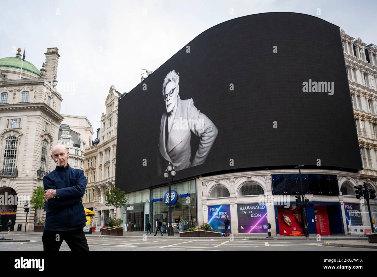 London, UK.  8 August 2023. Photographic artist Ray Burmiston at the launch of ‘Art of London Presents Take A Moment 2023’, his new photography exhibition featuring hundreds of famous faces with their eyes closed for mental health awareness.  Faces, including Eddie Izzard, are seen on the big screens at Piccadilly Circus, ahead of an exhibition in the National Portrait Gallery in September.  Credit: Stephen Chung / Alamy Live News Stock Photo