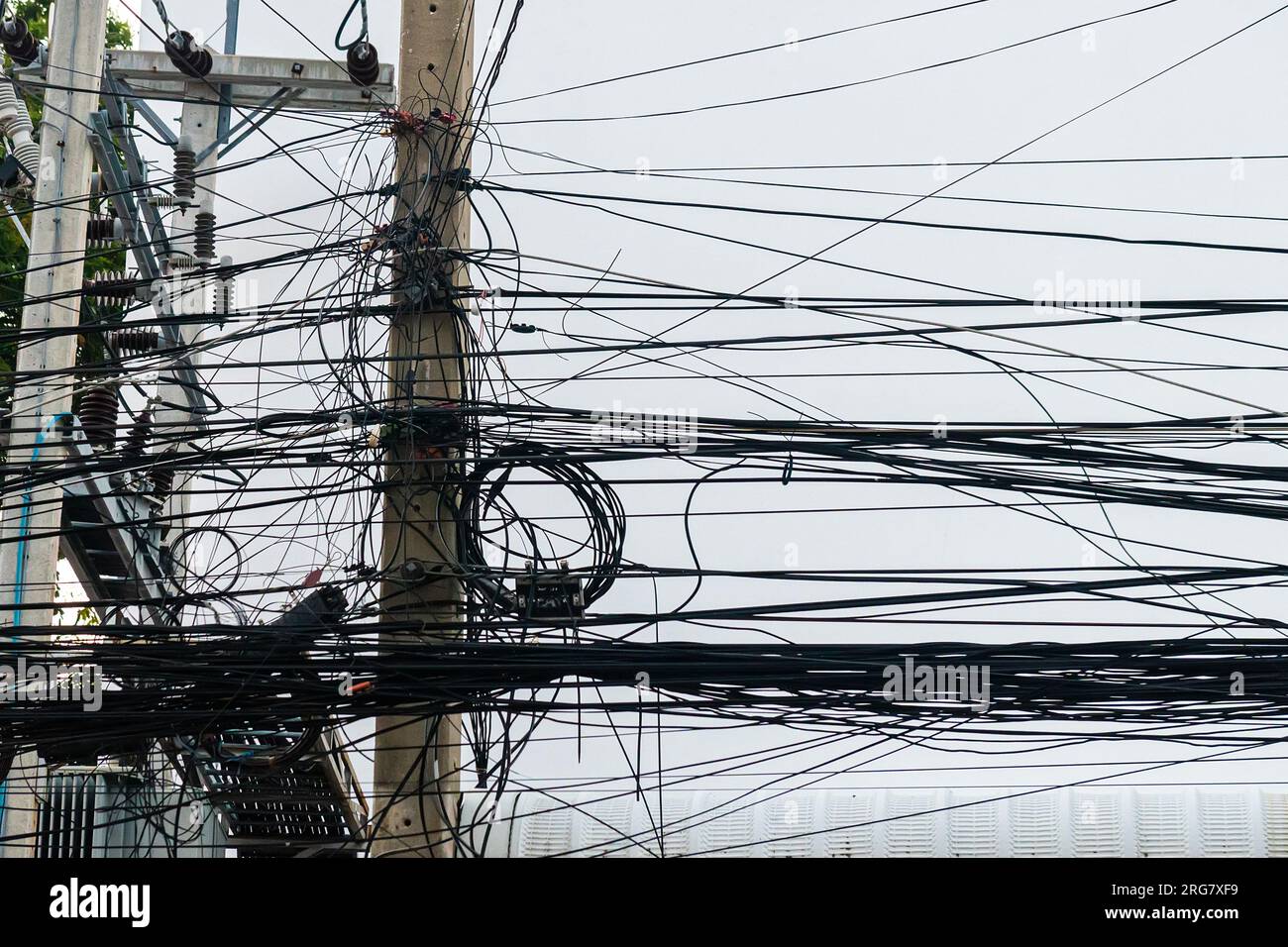 Messy wires attached to the electric mast. The chaos of cables and