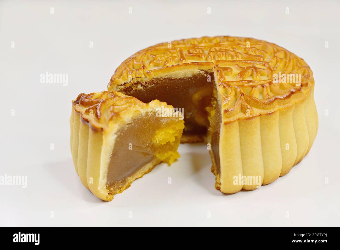 A baked Chinese mooncake with lotus seed paste and a quartercut wedge