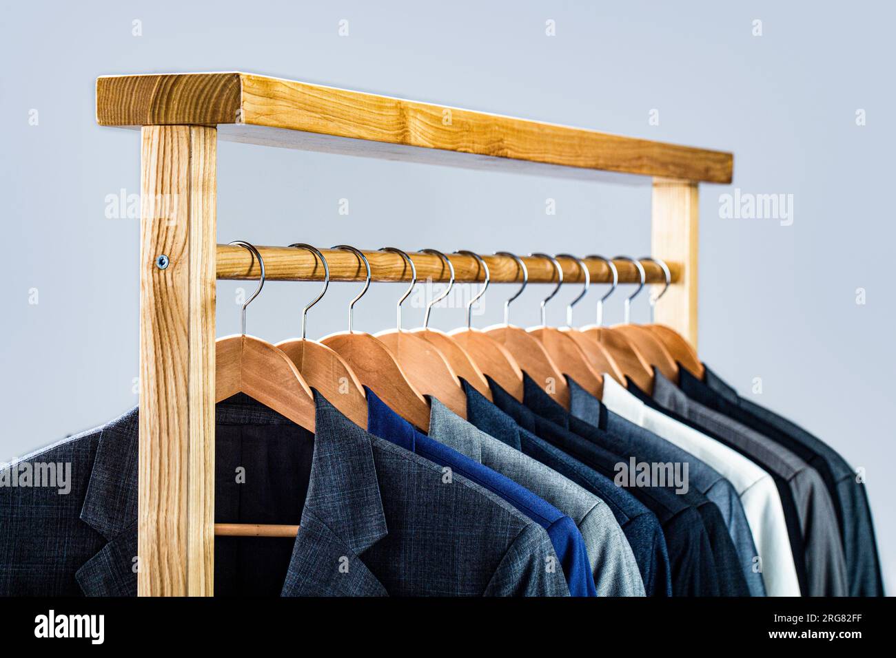 Suits for men hanging on the rack. Mens suits in different colors hanging on hanger in a retail clothes store close up. Mens shirts suit hanging on Stock Photo Alamy