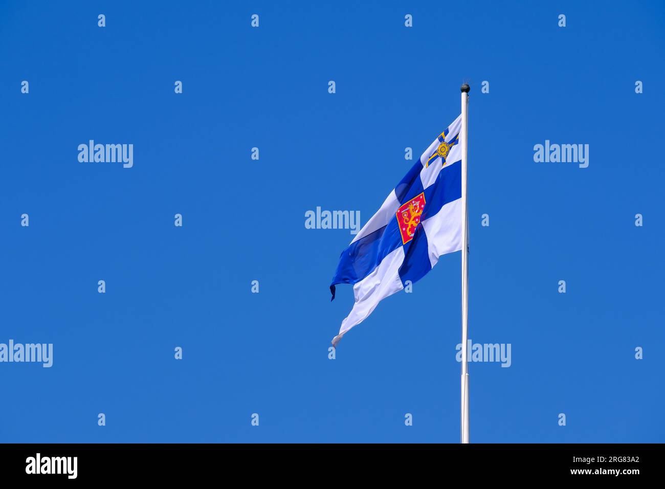 Helsinki / Finland - JUNE 27, 2023: Finnish state flag waiving in the wind against a bright blue sky. Stock Photo