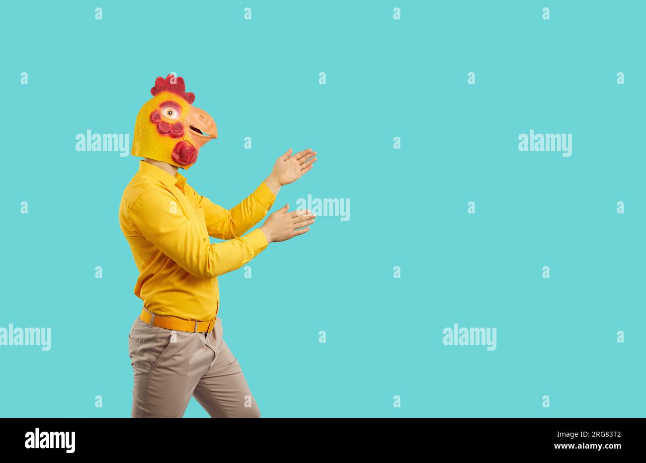 Funny man in silly mask of chicken head dancing like robot isolated on
